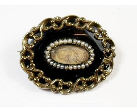A 19th century gilt metal and black enamel mourning brooch inset with pearls and woven hair, inscribed to the rear 'To the Me