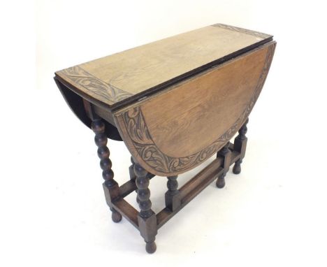 An early 20th century oak dropleaf dining table with carved border and bobbin turned supports 84cm long x 73cm tall