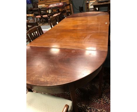 A Sheraton style mahogany D-end dining table with central drop leaf section on square tapered legs and spade feet  12 legs in