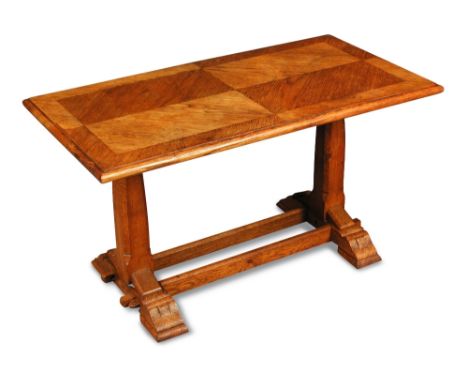 An 'Axe-man' oak coffee table, the quarter veneered rectangular top on sleigh feet united by double stretcher, carved 'axes' 