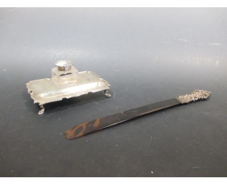 An Edwardian silver inkstand with well and pen recess, on hoof feet, London 1911 and a silver mounted page turner (2)  