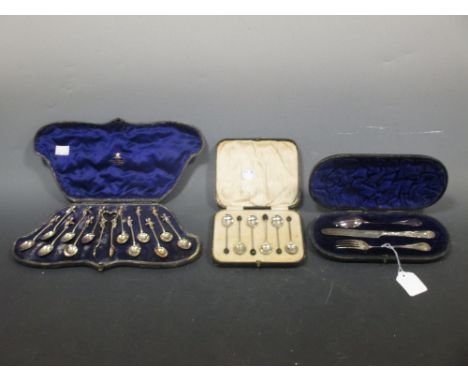 A set of twelve cherub headed coffee spoons with sugar tongs en suite, London 1872, shaped and fitted case; a set of six case