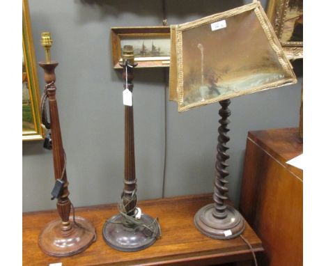 A carved wooden table lamp with fishing scene shade together with two other carved wooden lamps (3)  