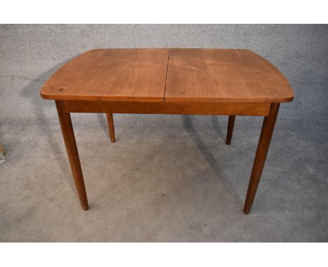 A mid 20th century vintage teak extending dining table with swivel leaves fitted to the underside. H.76x117cm (ext.166cm) 