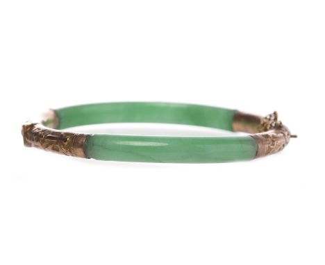 CHINESE TWENTY CARAT GOLD MOUNTED JADE BANGLE BY TUCK CHANGthe jade with overlaid engraved gold fittings, 74mm wide, 24.4g