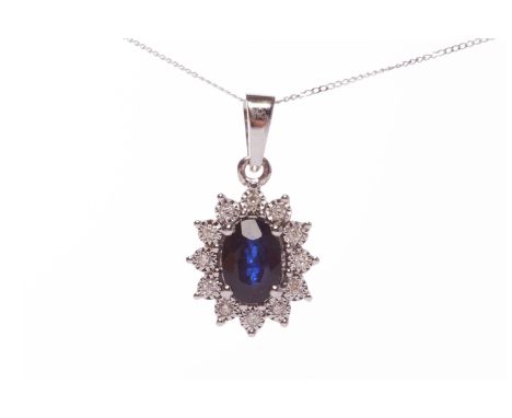 SAPPHIRE AND DIAMOND CLUSTER PENDANTset with a central oval sapphire 7.4x5.2mm and within a round brilliant cut diamond halo,