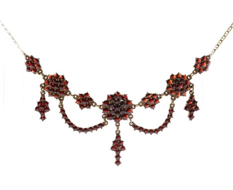 GARNET SET NECKLACEwith a central floral cluster with suspended garnet drop section, with further floral clusters in looped s