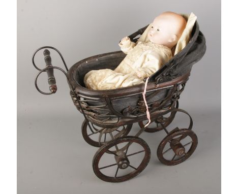An Armand Marseille bisque headed baby doll along with small dolls pram.