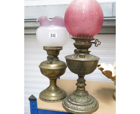 A Victorian opaque glass oil lamp, and a brass example with a pink glass reservoir (2)