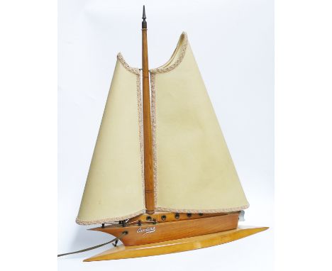 A novelty wooden table lamp, modelled as a yacht, Carolina with twin parchment sail shades and rudder switch