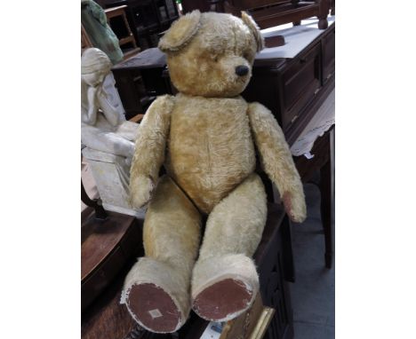 A large Chad Valley golden plush teddy bear, straw filled, with vertically stitched nose and one eye, height 115cm.