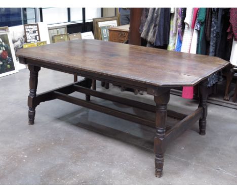 A traditional country oak kitchen table, moulded octagonal top, outswept ring-turned legs, united by a stretcher, 185 by 112c