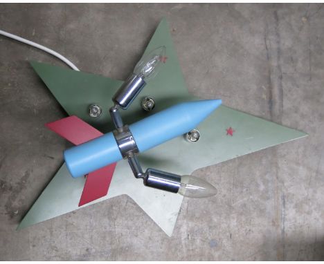 A stylised star and rocket wall light,  green painted wooden star with red star motifs,  the blue painted, red tailed rocket 