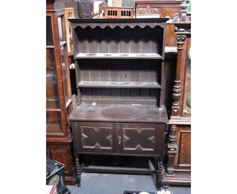 A traditional oak dresser, with plate rack and geometric panel cupboards, on barleytwist legs, 188 by 107 by 45cm.