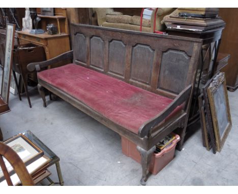 A George III country oak settle, panel back, scroll arms (one detached), cabriole legs, 108 by 185 by 62cm.