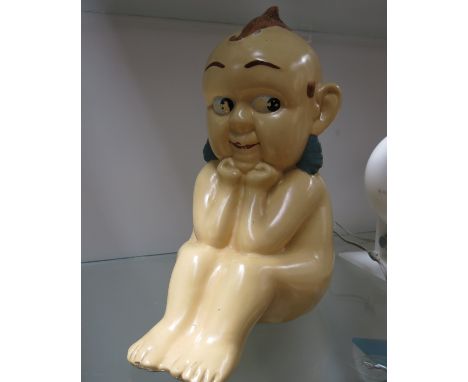 A large ceramic figure of a Pixie, circa 1950, seated with elbows on knees, indistinct stamped mark