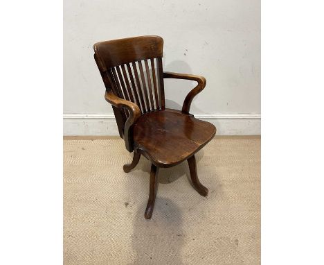 An Edwardian beech swivel desk chair, on four legs, height 85cm, with an oak ladder back arm chair, with rush seat (2)