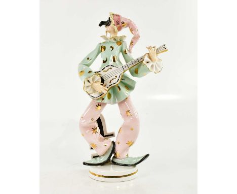 A mid century Italian pottery figure representing a masked clown playing a guitar, height 43cm.