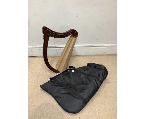 A small modern carved hardwood harp, height 70cm, fitted in canvas bag.
