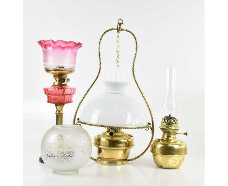 A late Victorian oil lamp, with cranberry and clear glass shade and etched decoration, with cranberry glass reservoir and bra