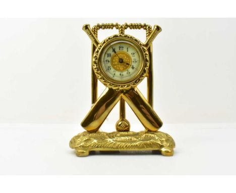 A late 19th/early 20th century brass mantel clock of cricket theme, the body presented in the form of stumps with crossed bat