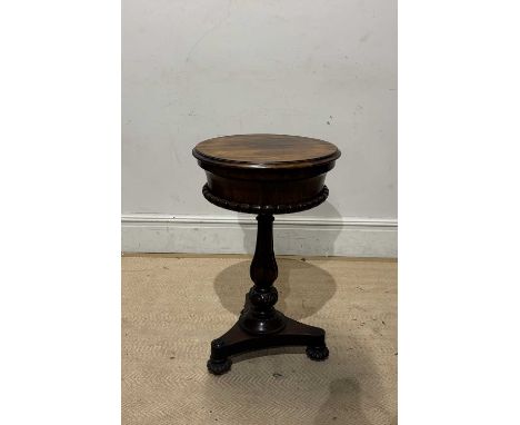 A 19th century rosewood circular teapoy, the hinged cover enclosing fitted compartments and glass mixing bowls, on fluted col