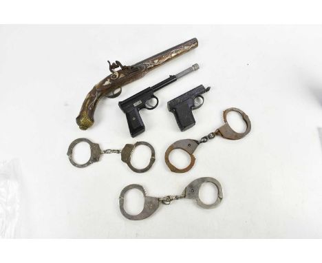 A decorative Eastern metal and mother of pearl inlaid flintlock pistol, a vintage Gat gun, a cigarette lighter formed as a gu