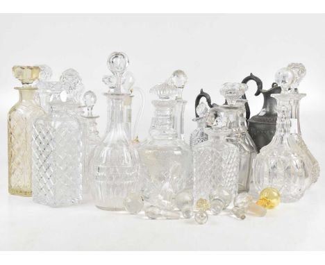A collection of 19th century and later decanters, two pewter jugs and assorted decanter stoppers.