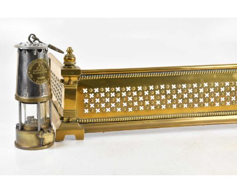 An Eccles Protector silvered metal and brass miner's lamp, height 26cm, and a pierced brass fender, width 136cm (2).