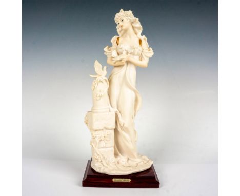 A beautiful porcelain figure of a woman with two doves atop of a glossy wooden base. Giuseppe Armani plaque on the front of t