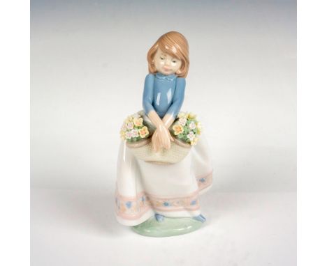 A glossy figure of a young girl holding a double basket of flowers. Lladro backstamp. This item has its original box: 8.25""L