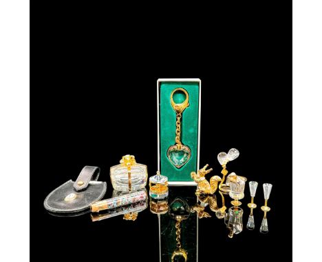 A stunning variety of Swarovski cut crystal items. Includes present box with gold-tone ribbon and tube of gems, miniature Swa