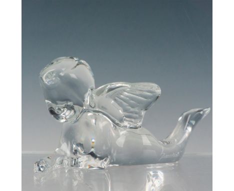 A clear crystal figurine depicting a reclining angel with legs up. Baccarat factory label. Baccarat etched backstamp. This it