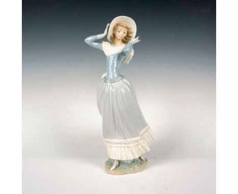 This figurine beautifully captures the essence of a lovely young woman, savoring the gentle breeze as it playfully moves her 