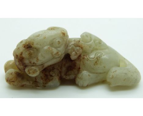 Chinese carved celadon and russet jade Dog of Fo, 2.6x7cm
