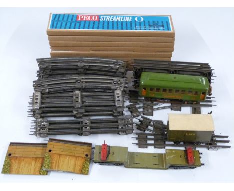 A collection of 0 gauge model railway rolling stock, accessories and track including Lionel Pullman coach, Bassett Lowke LMS 