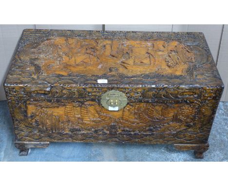 Chinese heavily carved camphor wood trunk with engraved brass lock raised on carved bracket feet, W78 x D44 x H45cm