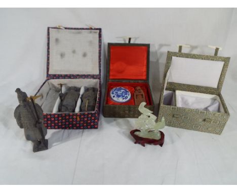 Three boxed tourist ware collectables including models of the Terracotta Warriors, a jade bird on stand and a Chinese wax pot