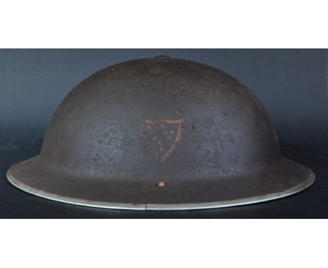 A WWII Second World War British Army MKII steel combat helmet. Usual form with outer steel rim and the remains of a Devon and