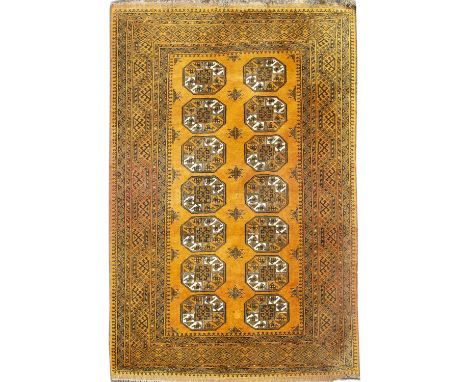 Gold ground sofa carpet Afghanistan, with two rows of elephant foot medallions, 290cm x 200cmGeneral light wear through use.