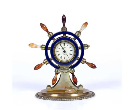 Brass and onyx ship's wheel model clockinset with blue enamel and on an oval base, with a later movement, 25cm high One onyx 