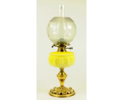 AN EDWARDIAN EMBOSSED BRASS OIL LAMP WITH PRIMROSE YELLOW MOULDED GLASS FOUNT AND BRASS BURNER