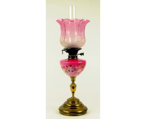 A VICTORIAN BRASS OIL LAMP WITH COLD PAINTED PEACH BLOOM GLASS FOUNT AND BRASS BURNER, ETCHED AND FROSTED CRANBERRY GLASS SHA