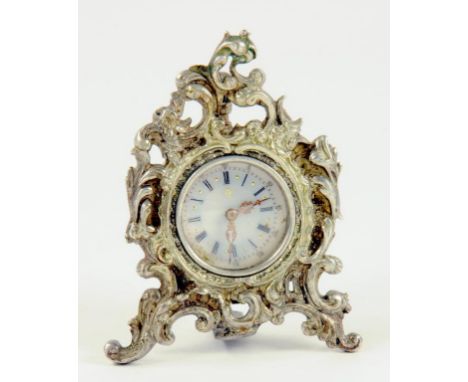 A CONTINENTAL ROCOCO REVIVAL MINIATURE SILVER STRUT CLOCK, THE WATCH TYPE MOVEMENT WITH ENAMEL DIAL AND GOLD FILIGREE HANDS, 
