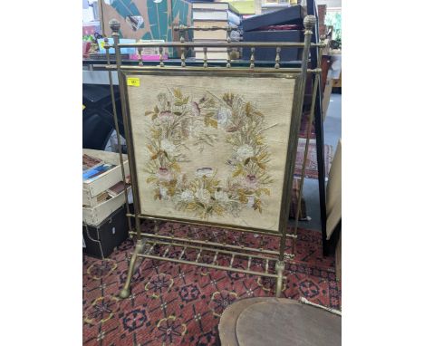 An aesthetic brass framed fire screen with an embroidered panel, an early 20th century walnut and ebonized finished mirror an