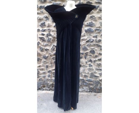 A black velvet full length opera cape having a Gothic style raised collar with a hook and eye and single button fastening and
