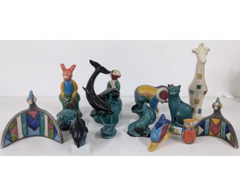 A group of ceramic and porcelain figurines to include Poole Pottery dolphins, South African giraffe mosaic style figurine and