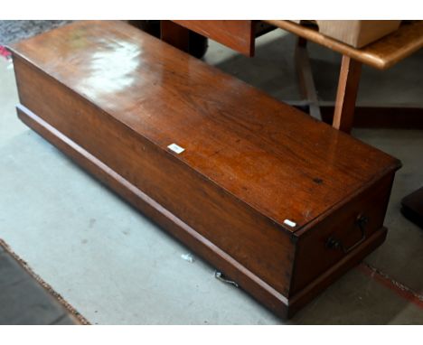An antique low hardwood brass handled trunk on casters, 112 cm wide x 37 cm deep x 30 cm high 
