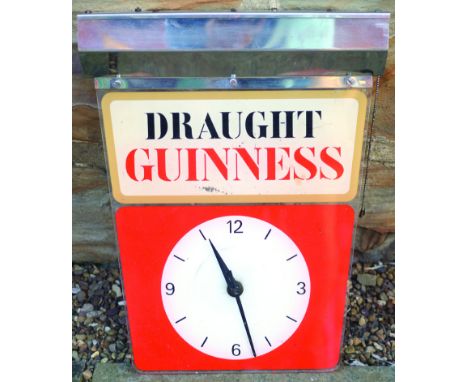 GUINNESS CLOCK. 17ins long, 13.5ins wide at chrome top. Perspex clock face with DRAUGHT/ GUINNESS to top in black & red lette