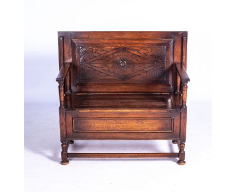 AN OAK MONKS BENCH, EARLY 20TH CENTURY  Convertible to a table with adjustable back panel the hinged seat enclosing a compart